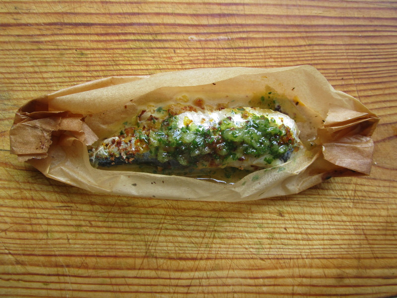Las sardinas con migas de pan y perejil picado sse asan en en horno sin olor en una caja de papel.