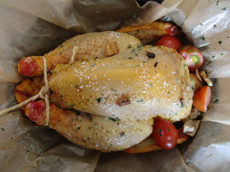 Preparando el pollo: rellénalo con tomates, ata las patas, unta el ave con manteca suave o lardo, y luego hace falta envolverlo en papel de horno. Preparando el pollo: rellénalo con tomates, ata las patas, unta el ave con manteca suave o lardo, y luego hace falta envolverlo en papel de horno.