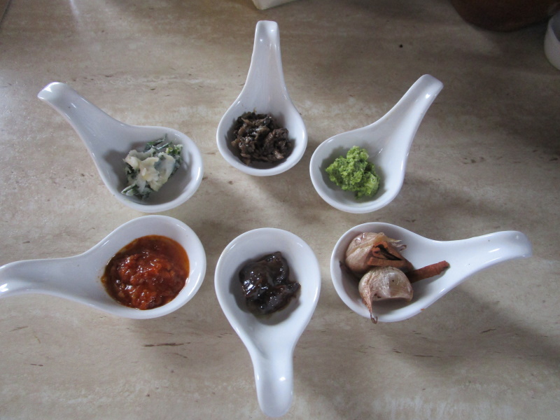 Aranjuez, 2022. Los sabores de Altamiras, preparados por una cata: tomate con naranja, azafrán, ajo y perejil; manteca blanda con perejil; pasta de avellanas, ajo y pan; crema de perejil, hierbabuena, lechuga y piñones; ajos asados en su piel, y setas silvestres estofadas. © Vicky Hayward