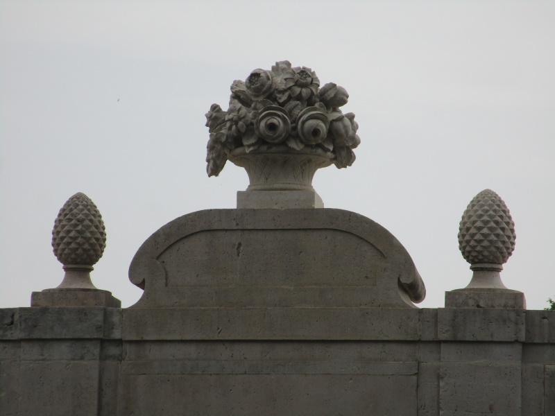 Las esculturas de piedra en el balcón al lado del Jardín del Príncipe incluyen una piña y un pedestal de flores.