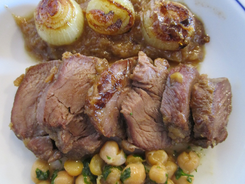 Carrillera de ternera trinchada en rodajas y servida con su ollita de garbanzos y cebollitas pochadas.